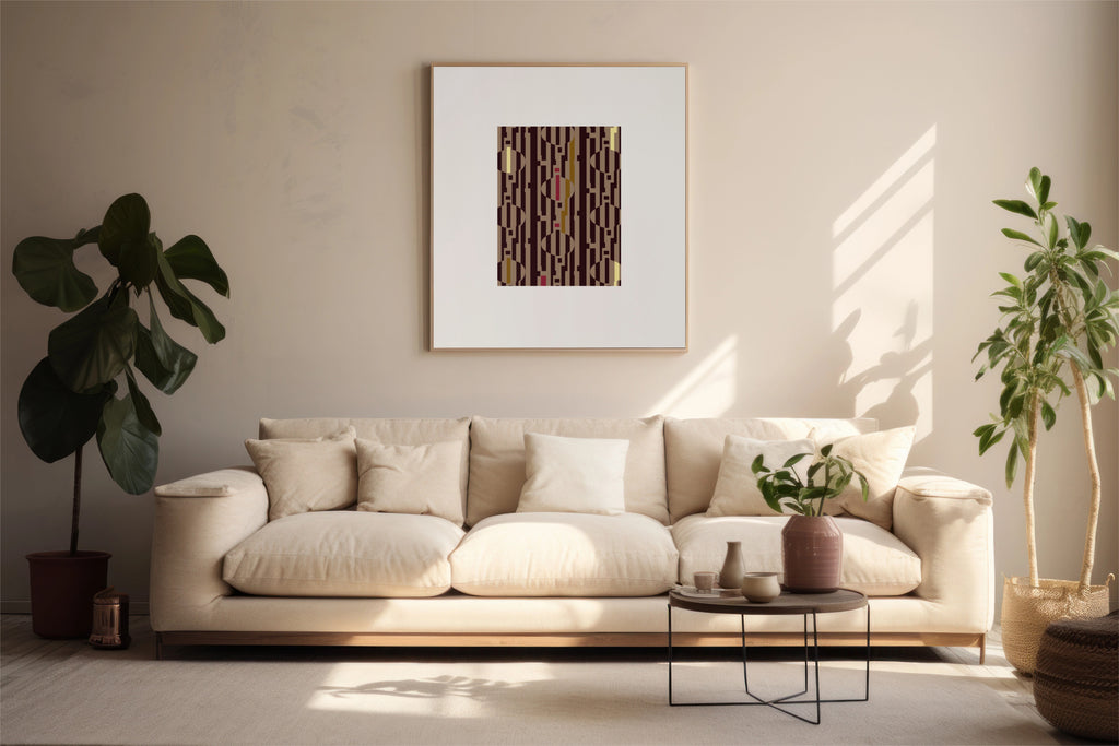 A framed abstract art print with vertical brown, pink, and yellow stripes hangs on a beige wall above a cream-colored sofa in a modern, sunlit living room with potted plants.