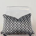 Decorative pillow with geometric pattern on a clear chair against a white background