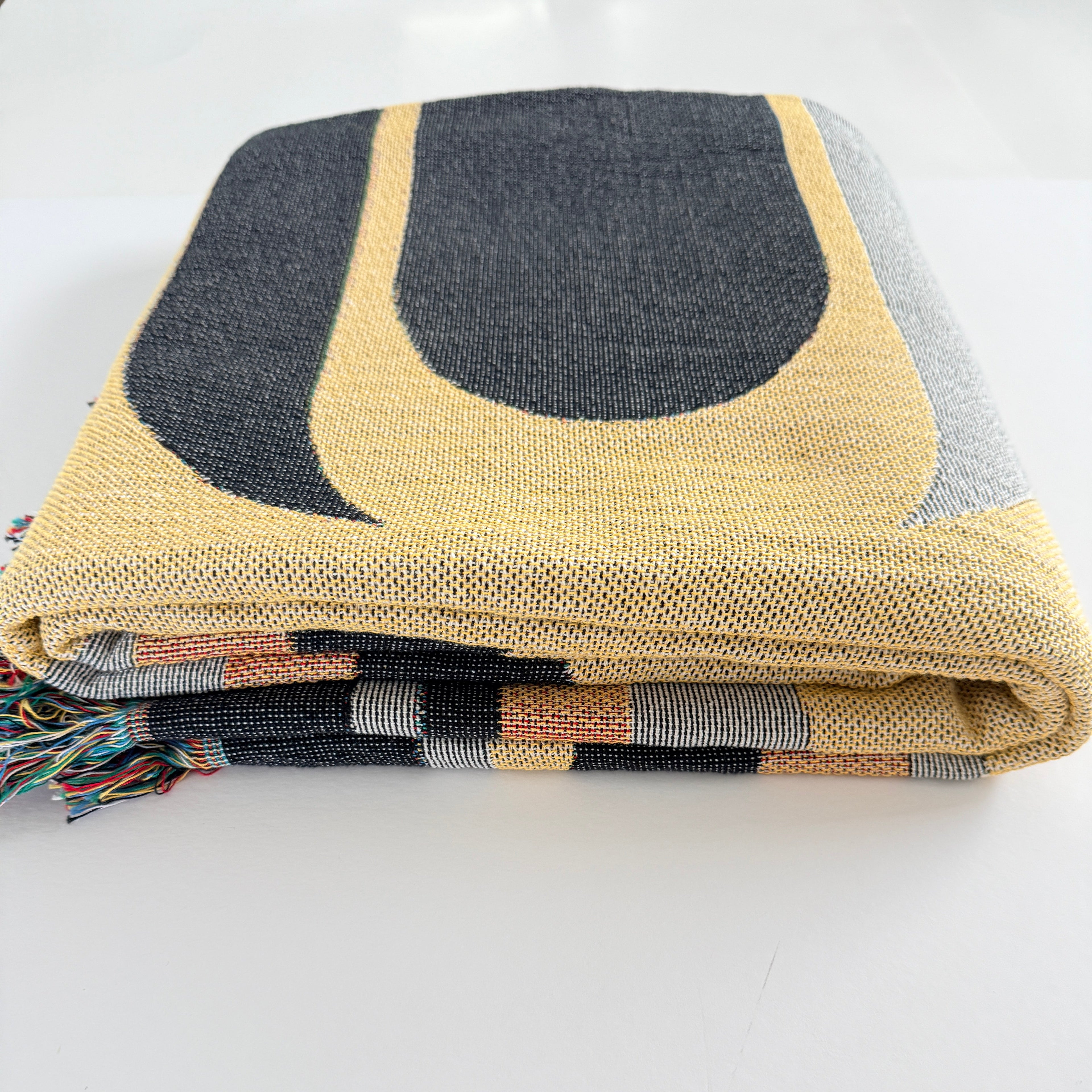 Textile art piece with geometric pattern on a plain background