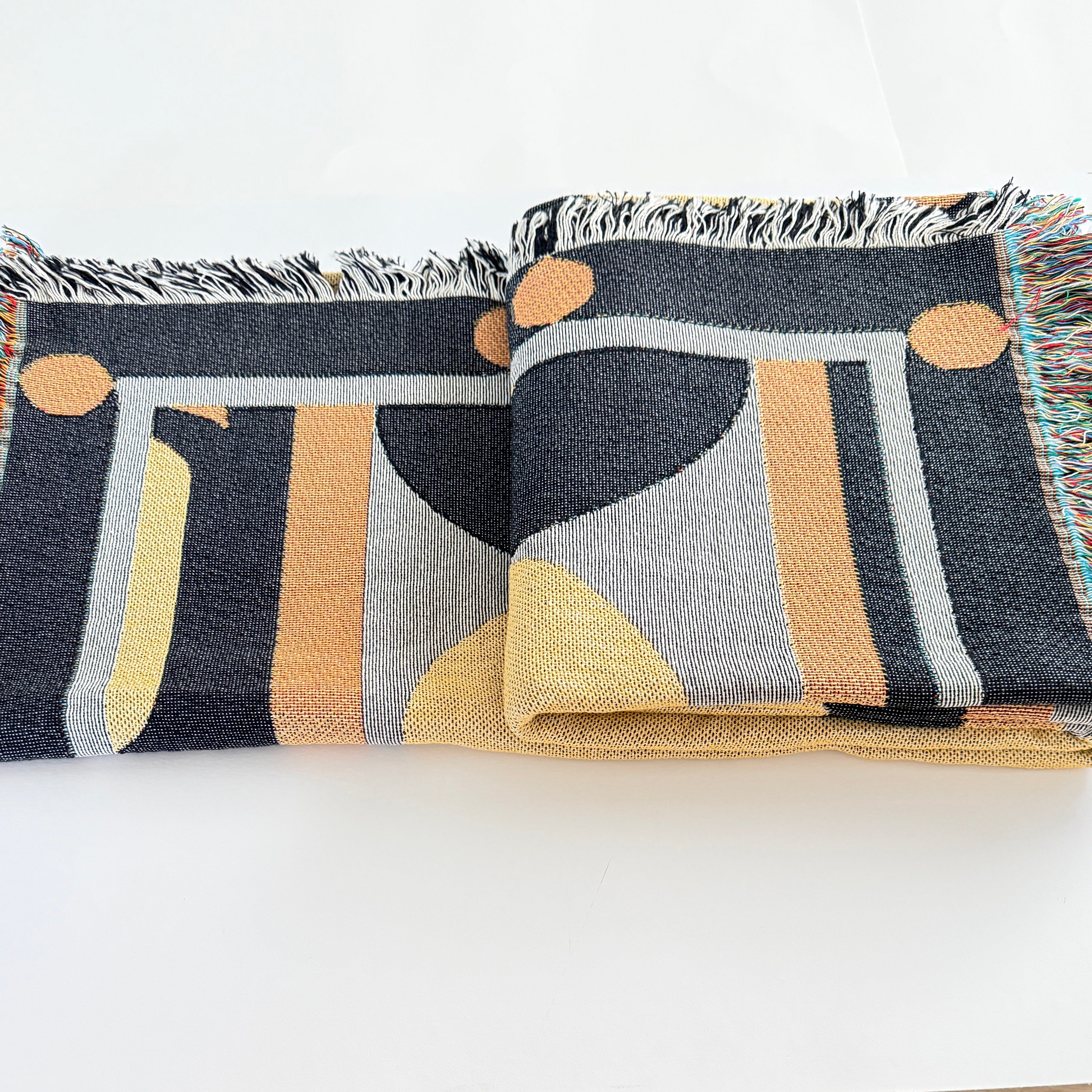 Patterned throw blanket with geometric designs on a white background