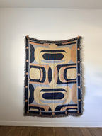 Decorative blanket with geometric pattern on a plain wall