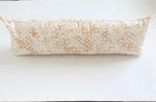 Long cylindrical pillow on a white surface