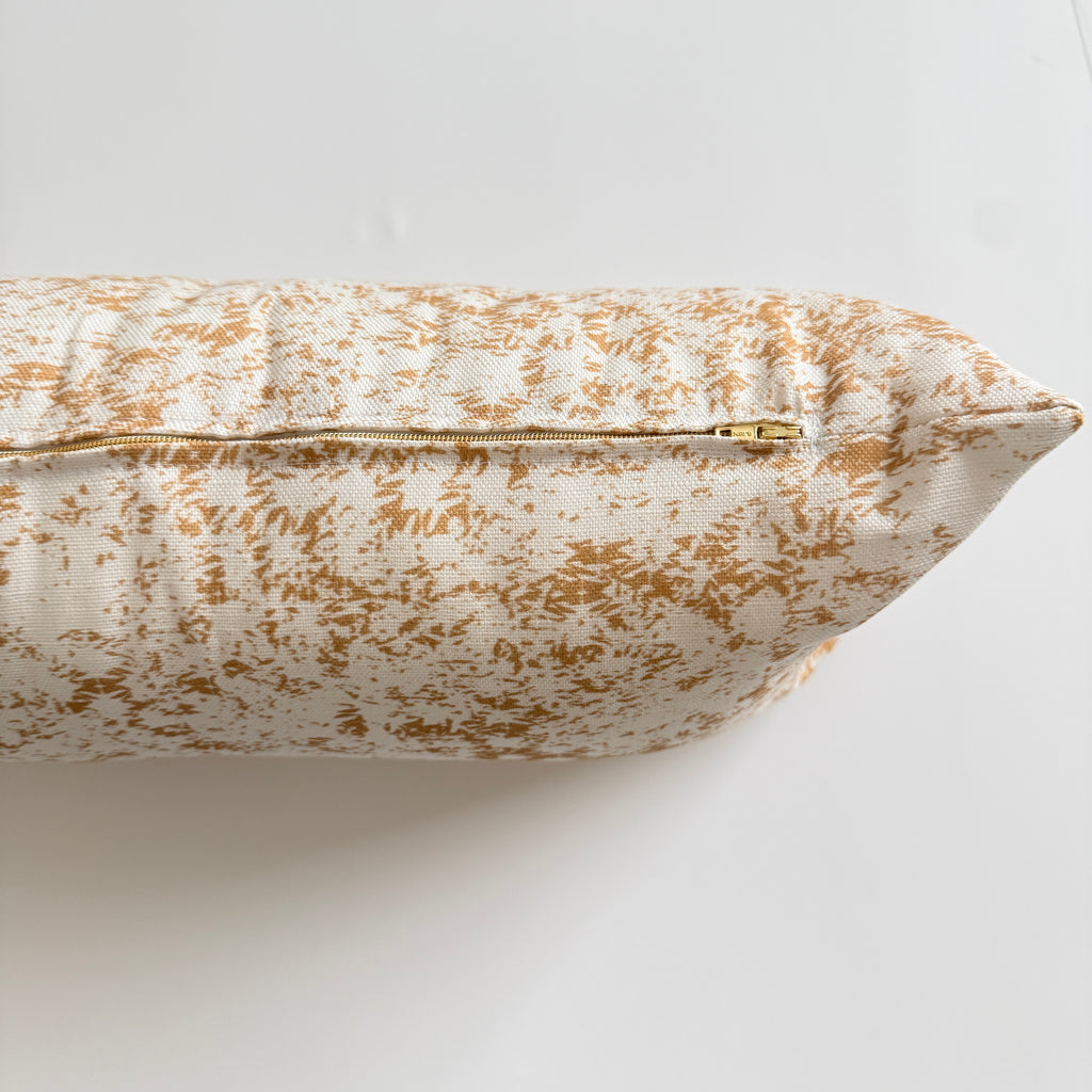 Decorative pillow with yellow and white pattern on a light background
