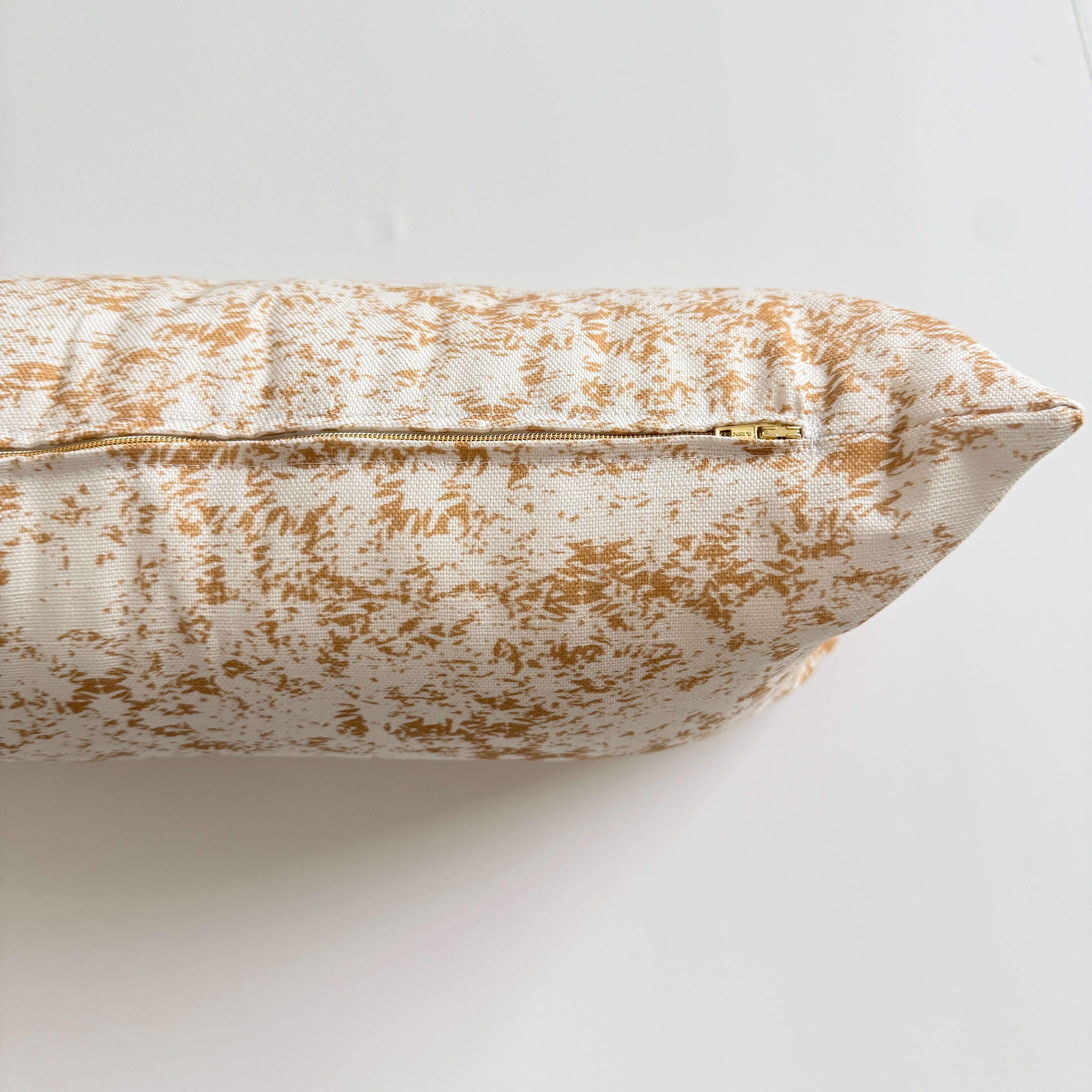 Decorative pillow with yellow and white pattern on a light background