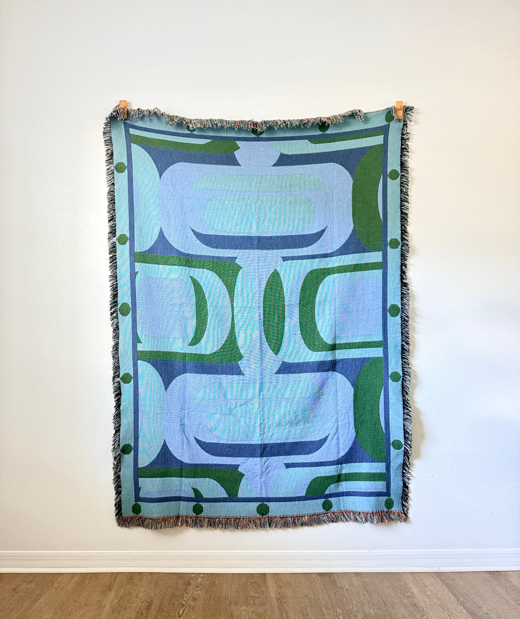 blue and green woven art against white background