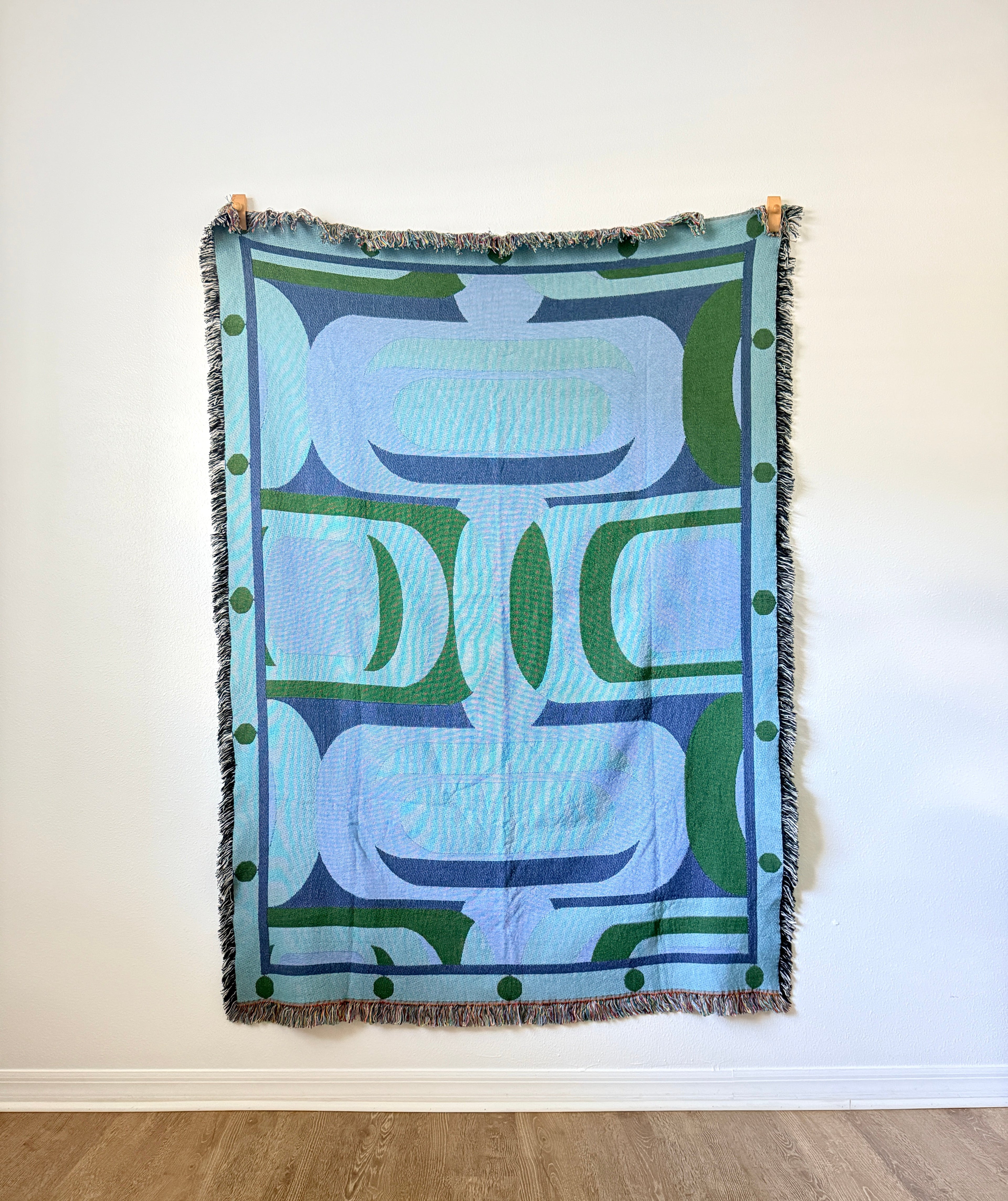 blue and green woven art against white background