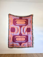 Decorative blanket with geometric pattern on a white wall