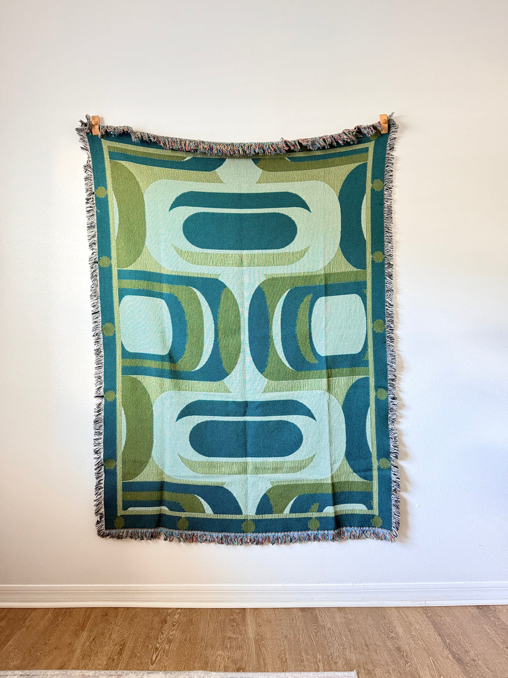 Decorative blanket with geometric pattern on a white wall