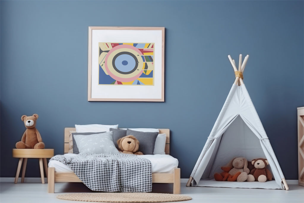A tan framed abstract geometric art print with concentric eye-like shapes in blue, pink, yellow, and white, hanging on a blue wall in kid room with wood bed and white tent with stuffed animals.