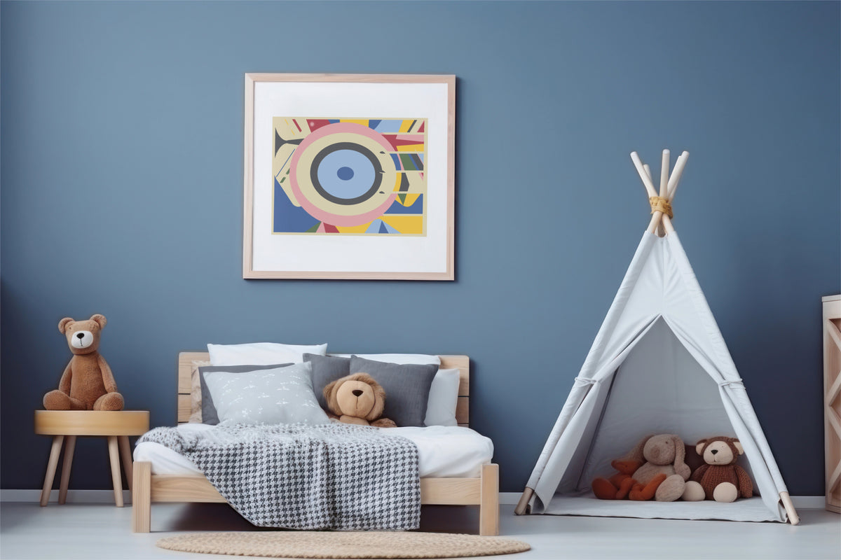 A tan framed abstract geometric art print with concentric eye-like shapes in blue, pink, yellow, and white, hanging on a blue wall in kid room with wood bed and white tent with stuffed animals.